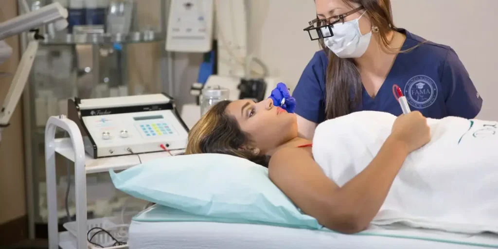 FAMA student wearing magnification loupes while performing a detailed electrolysis treatment.