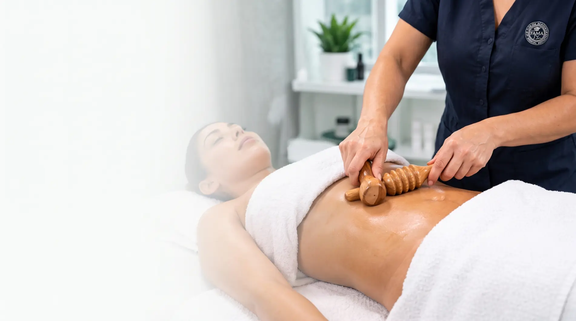 Instructor using wood therapy tools for abdominal body contouring on a client during the Advanced Wood Therapy Workshop at FAMA Academy in Florida